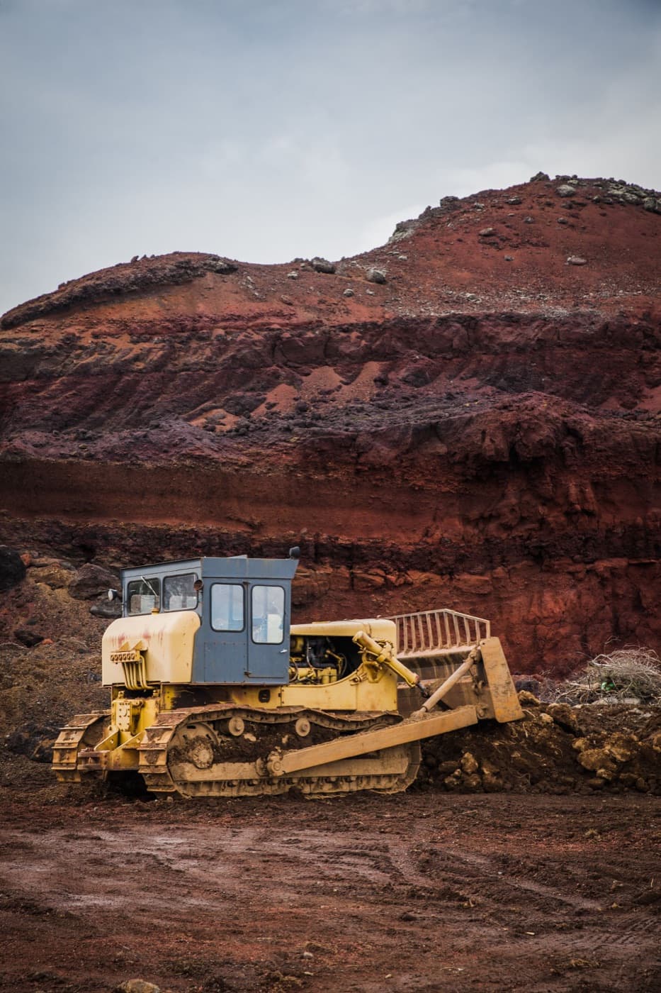 Tracked earthmoving equipment at a red-earth excavation; illustrative stock photography