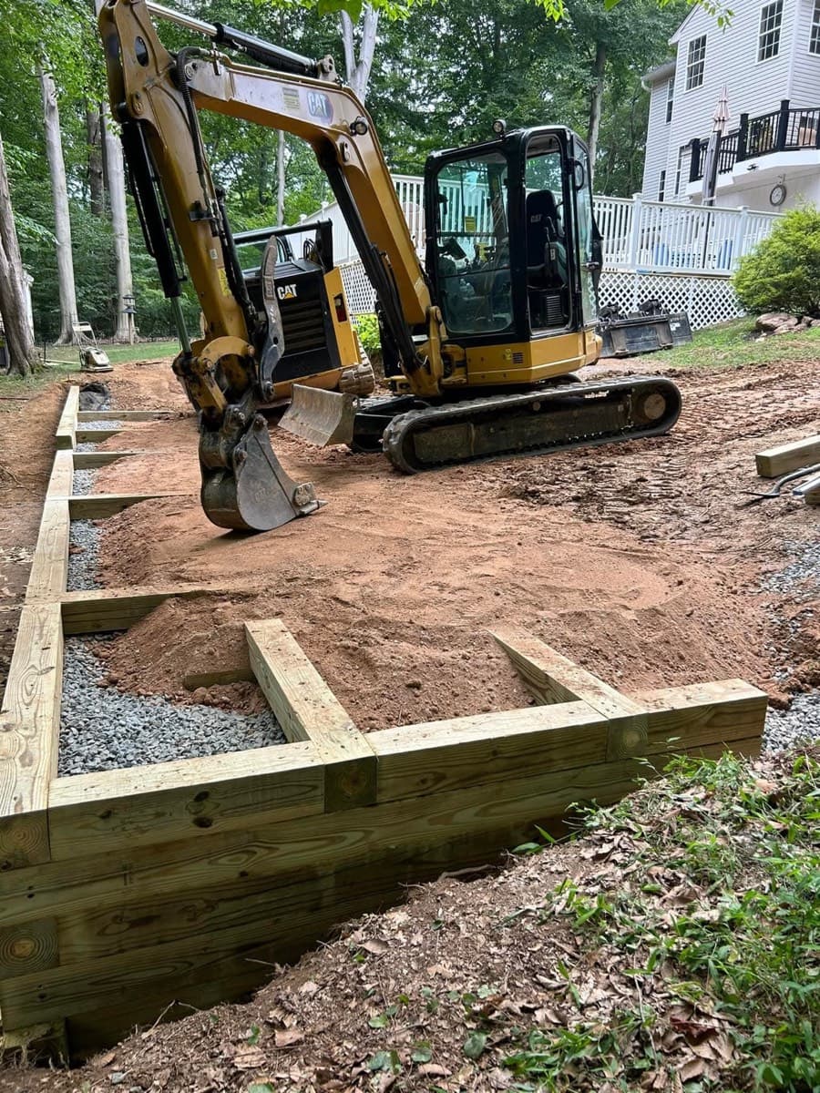 CAT excavator beside timber and gravel site preparation