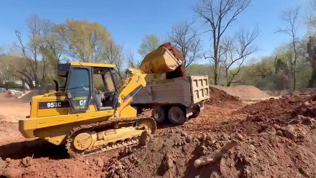 Tracked loader loading a dump truck