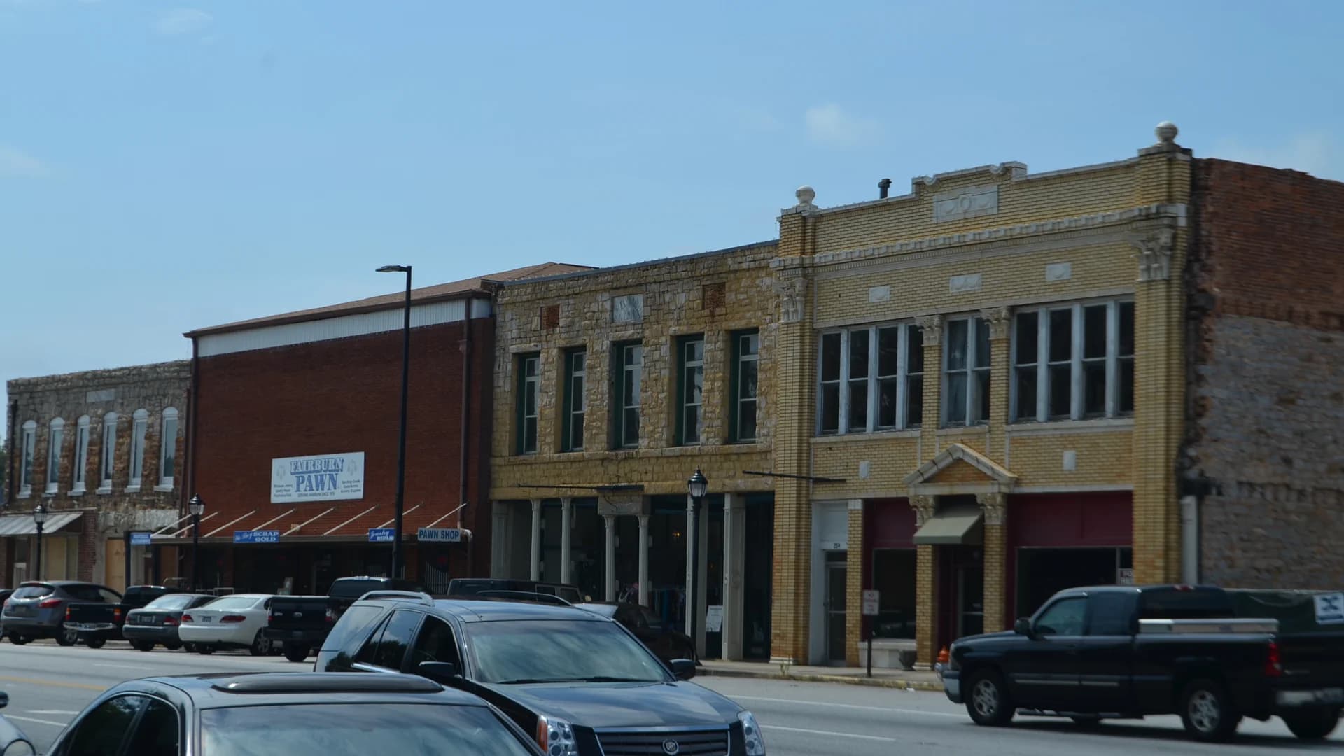Historic stone and brick storefronts along Broad Street in downtown Fairburn, Georgia.
